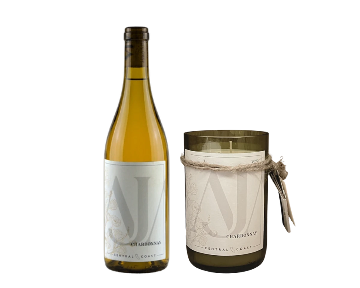 A bottle of AJA Chardonnay beside an AJA Chardonnay Citronella upcycled candle