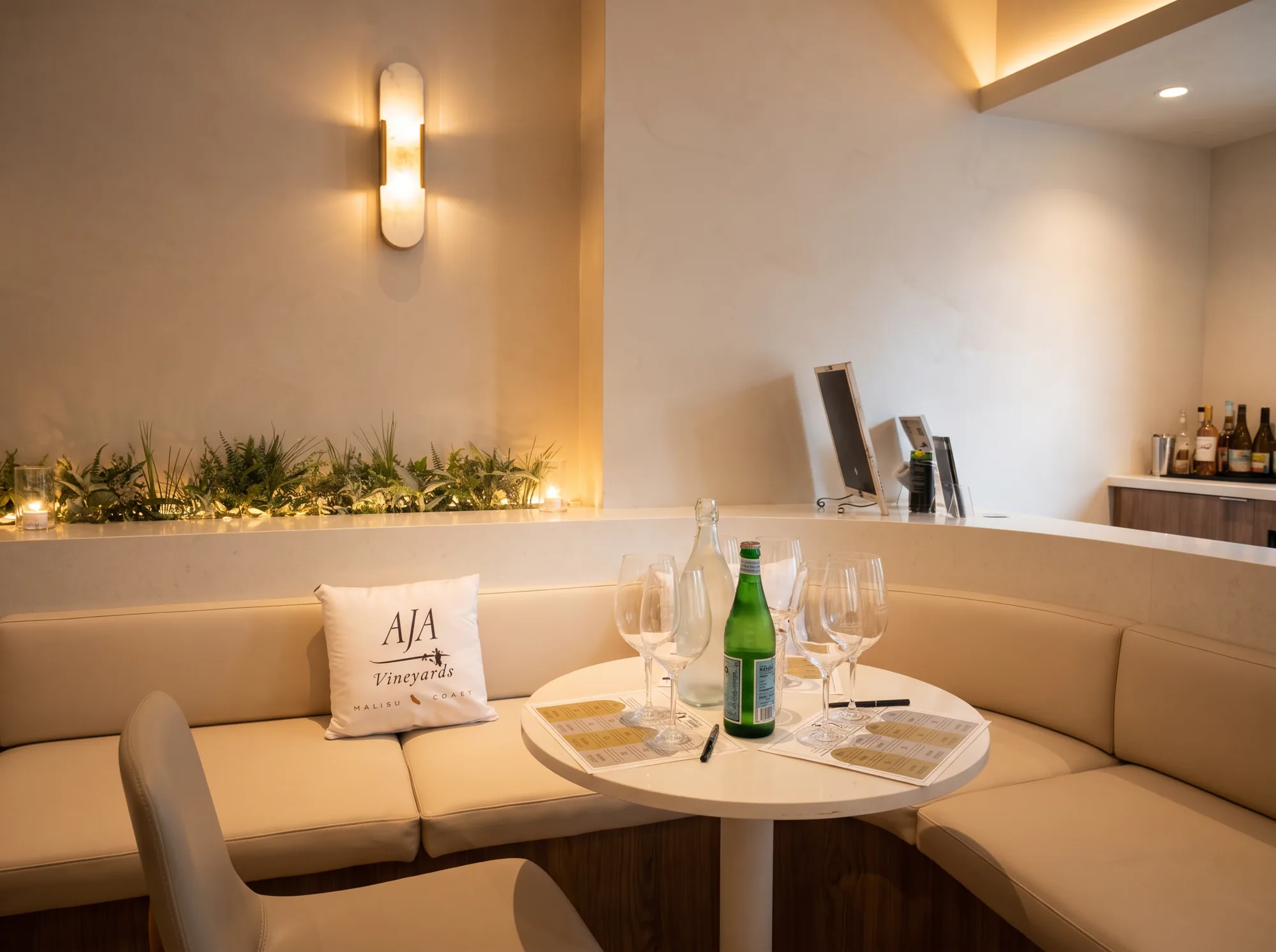 The curved banquette and tasting table inside the AJA Santa Monica room